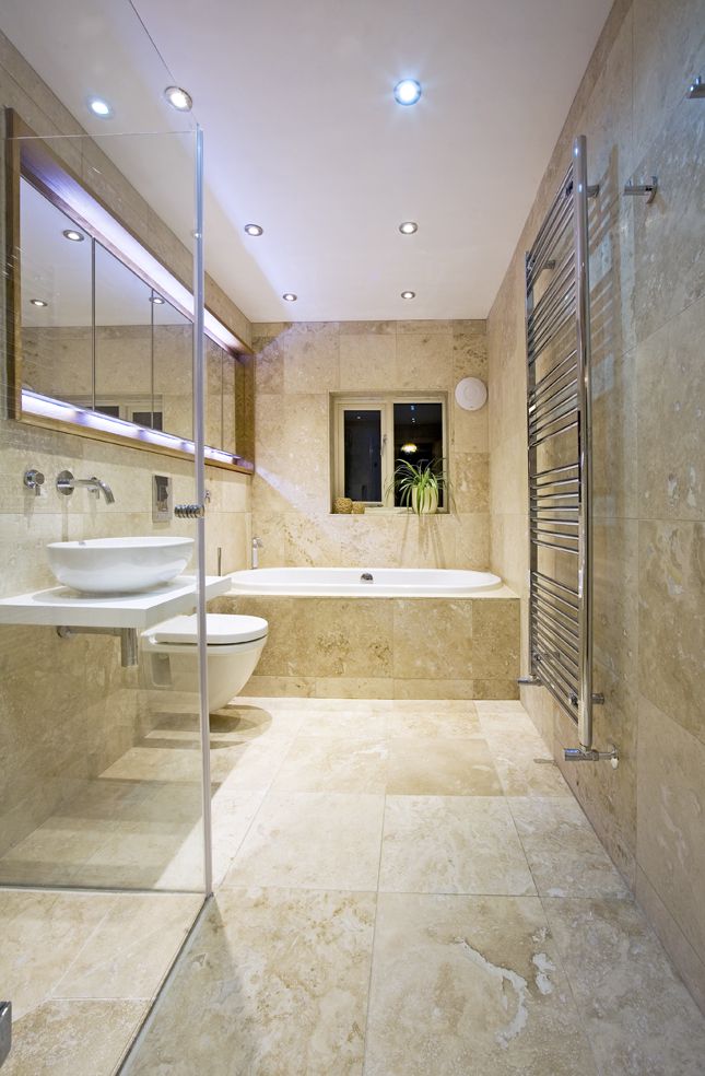 Yellow marble bathroom with a white bathtub, sink and toilet